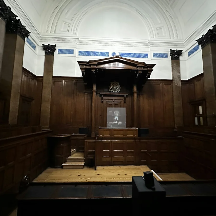 Sala de audiências vazia, com painéis de madeira.